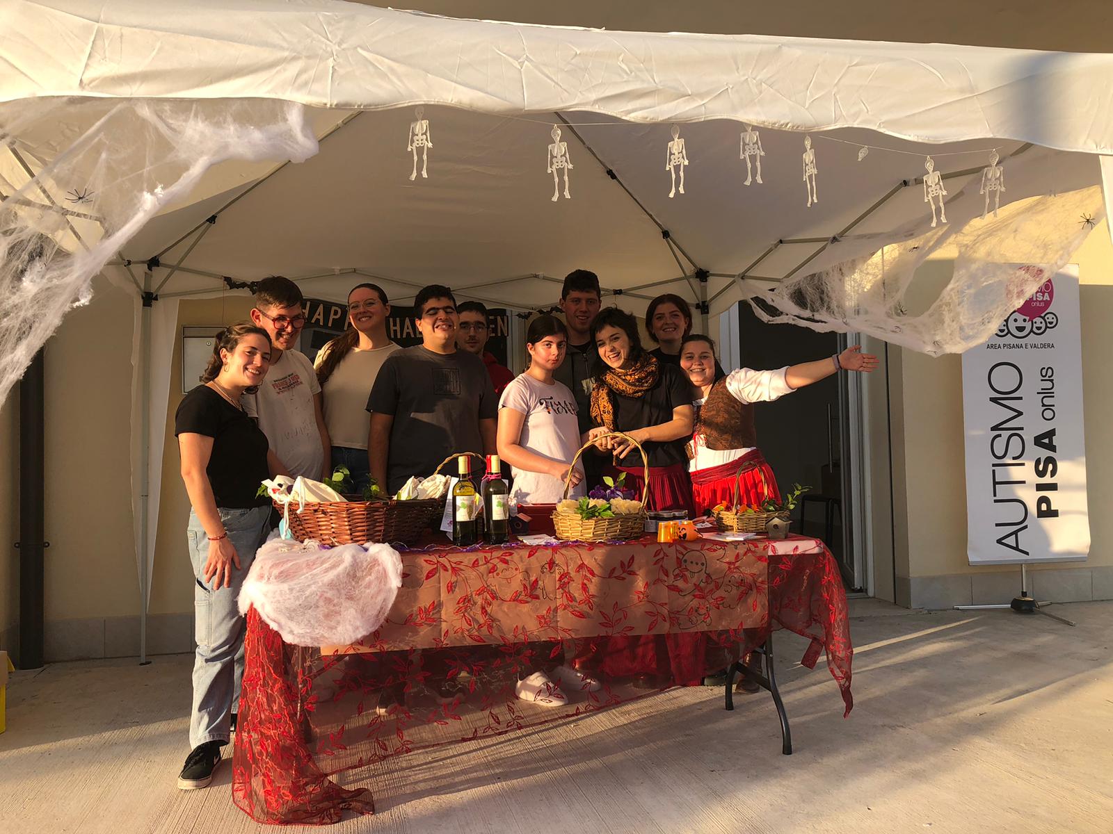 Un gruppo di ragazzi posano dietro al banchetto con i gadget creati da loro.